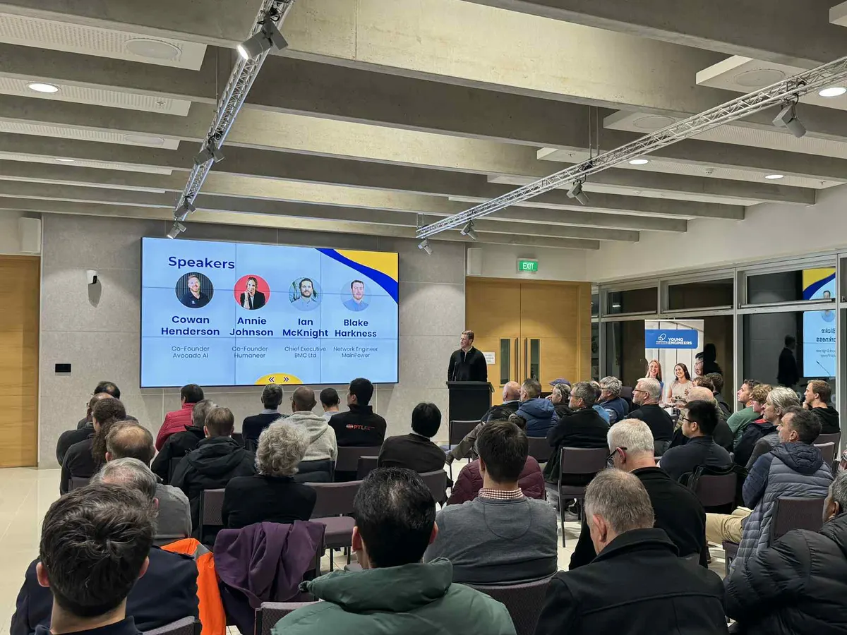 A full room at the Artificial Intelligence in Engineering evening at the University of Canterbury, with the speakers slide listing Blake Harkness of MainPower