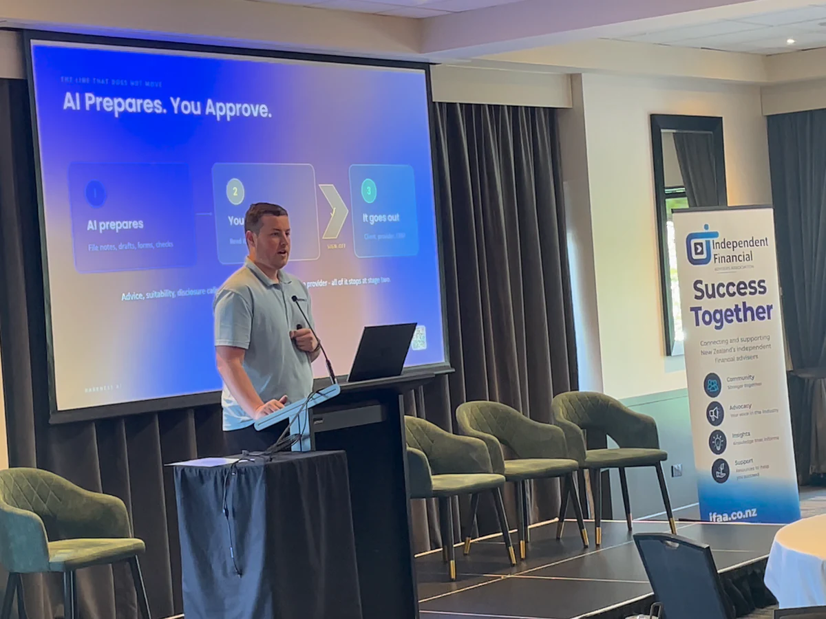 Blake Harkness speaking at the IFAA Conference 2026 in front of his slide AI Prepares. You Approve.
